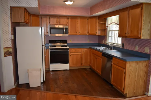 a kitchen with granite countertop stainless steel appliances and wooden cabinets
