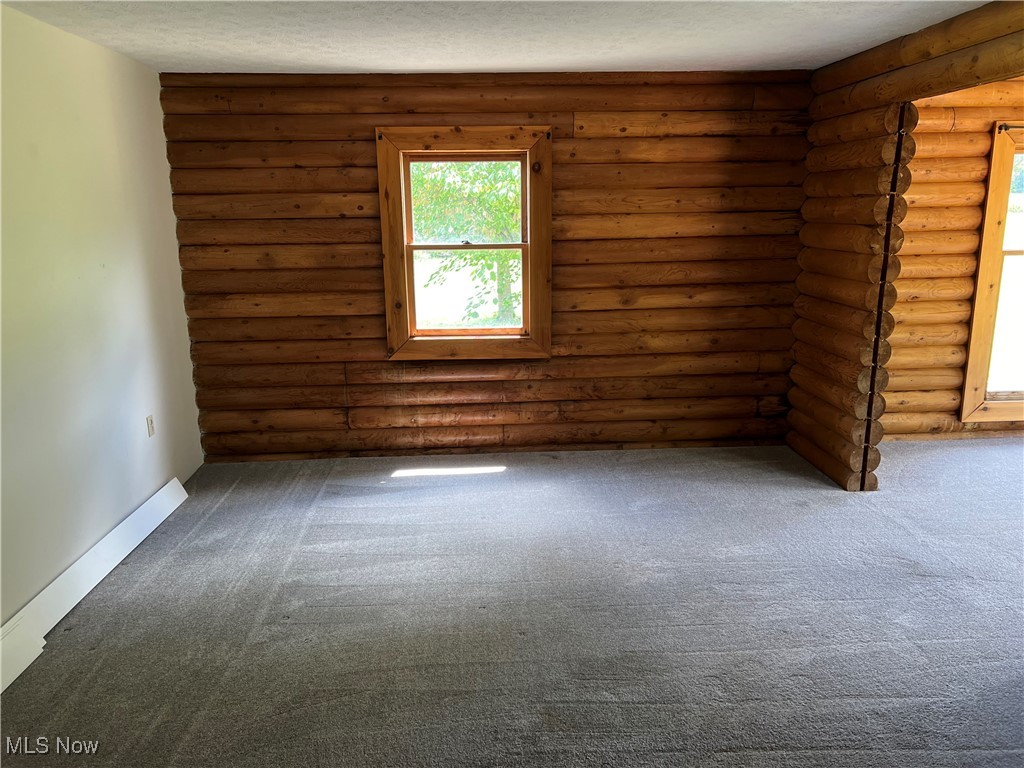 45499 Stewart Road Sullivan, OH 44880 - Photo 15 of 18 Carpeted spare room featuring log walls