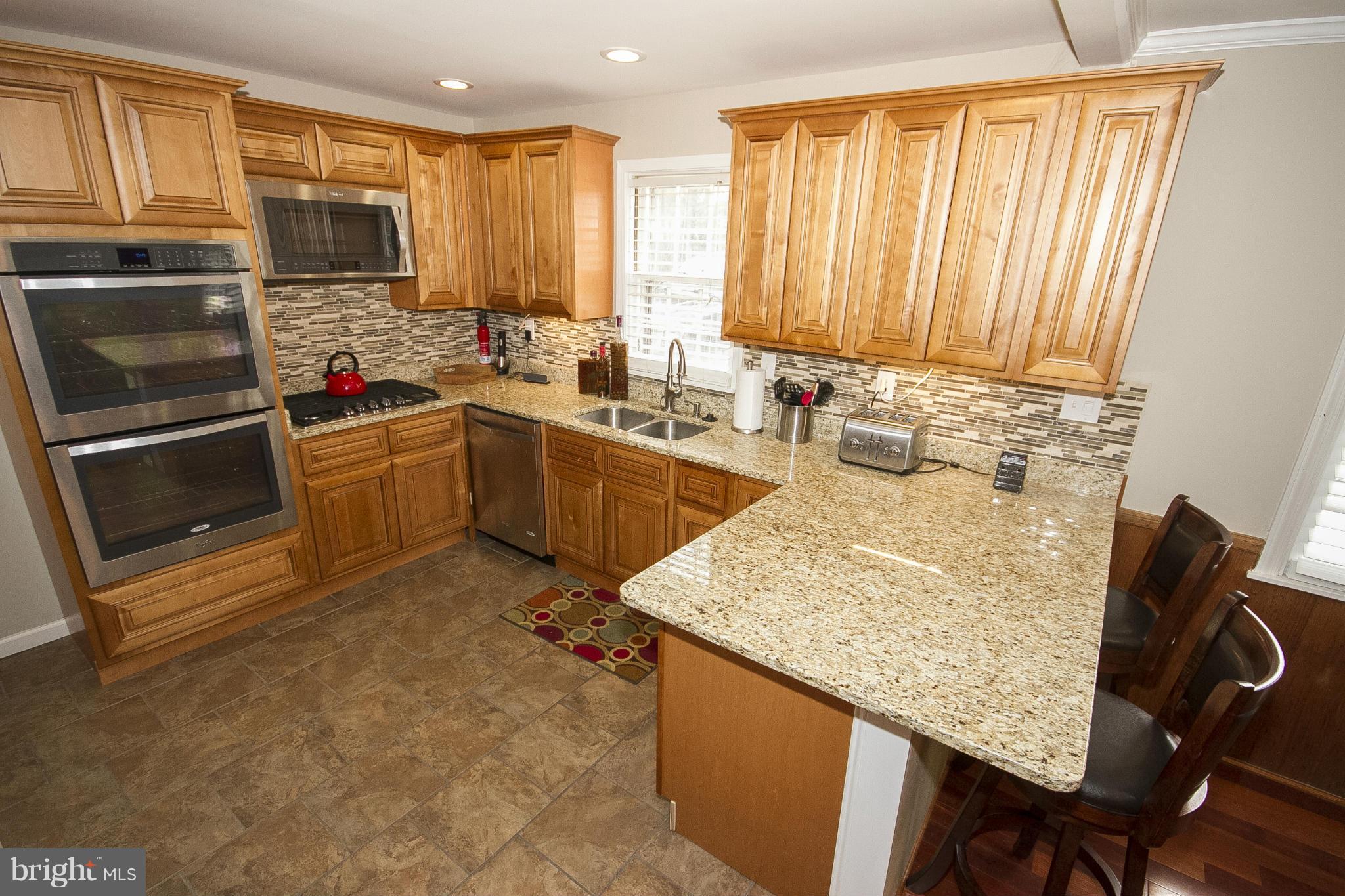 3605 Stoneybrook Road Randallstown, MD 21133 - Photo 13 of 25 a kitchen with a sink refrigerator and cabinets