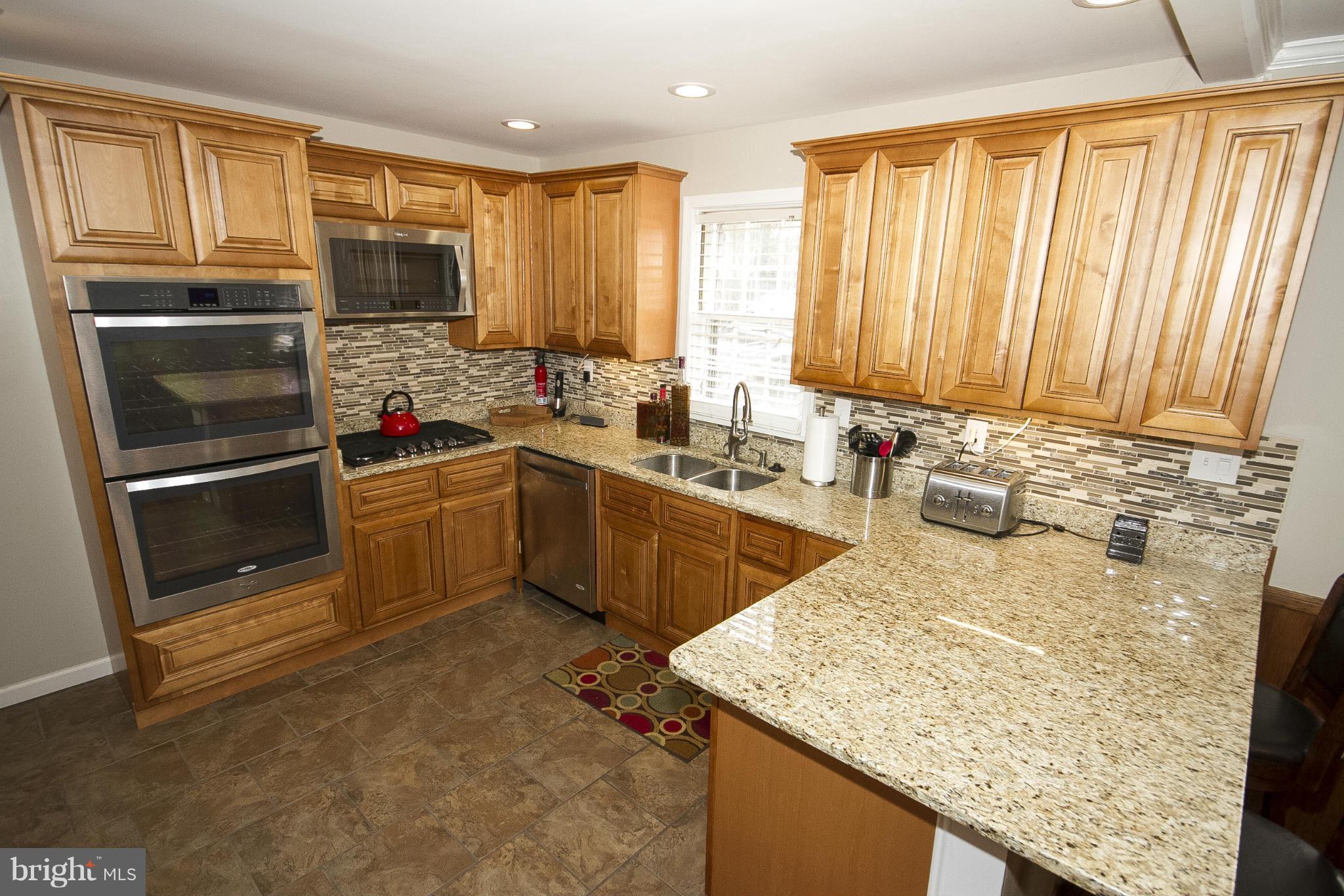 3605 Stoneybrook Road Randallstown, MD 21133 - Photo 14 of 25 a kitchen with a sink a stove and cabinets