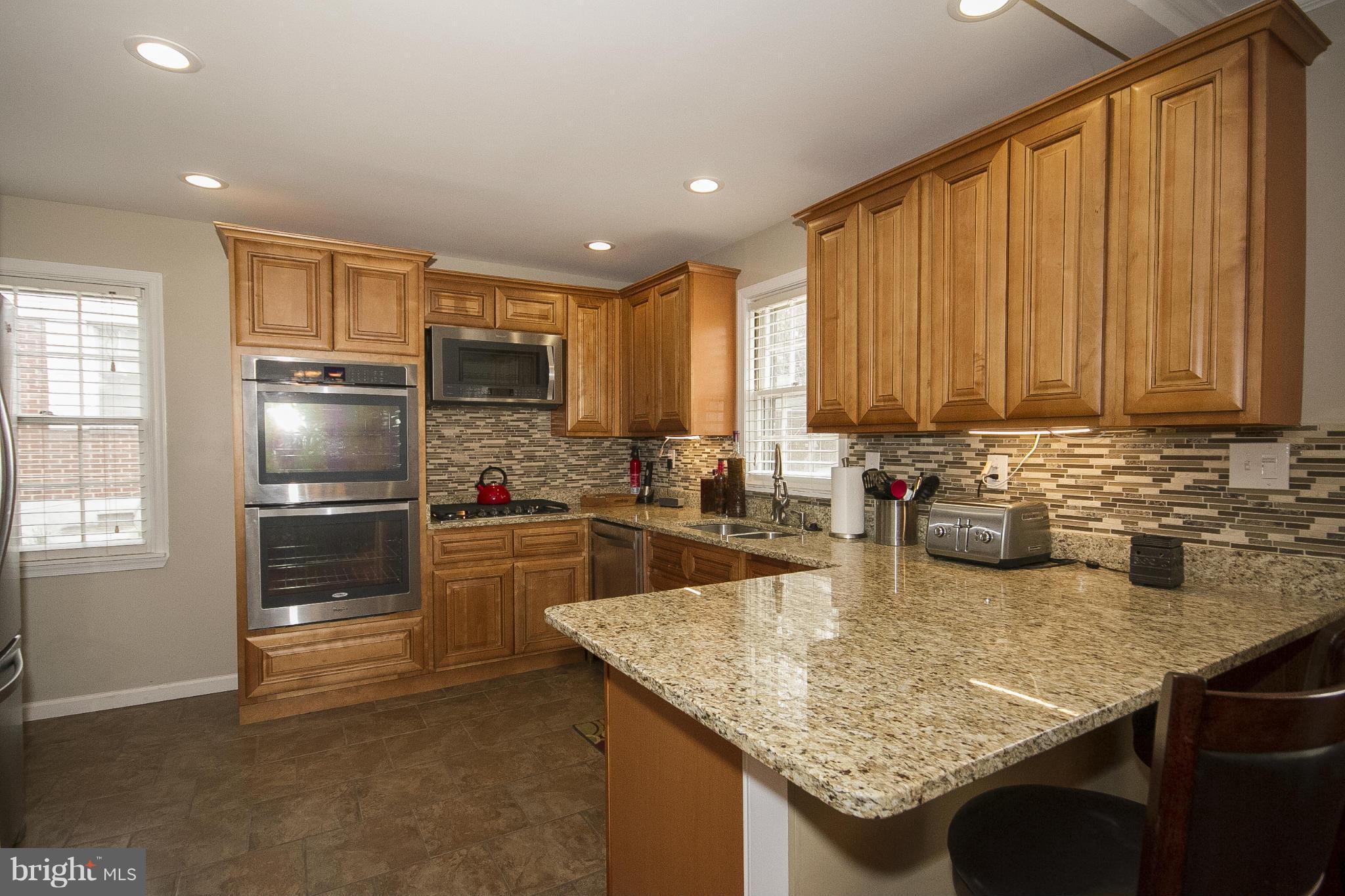 3605 Stoneybrook Road Randallstown, MD 21133 - Photo 9 of 25 a kitchen with granite countertop kitchen island a sink cabinets and stainless steel appliances