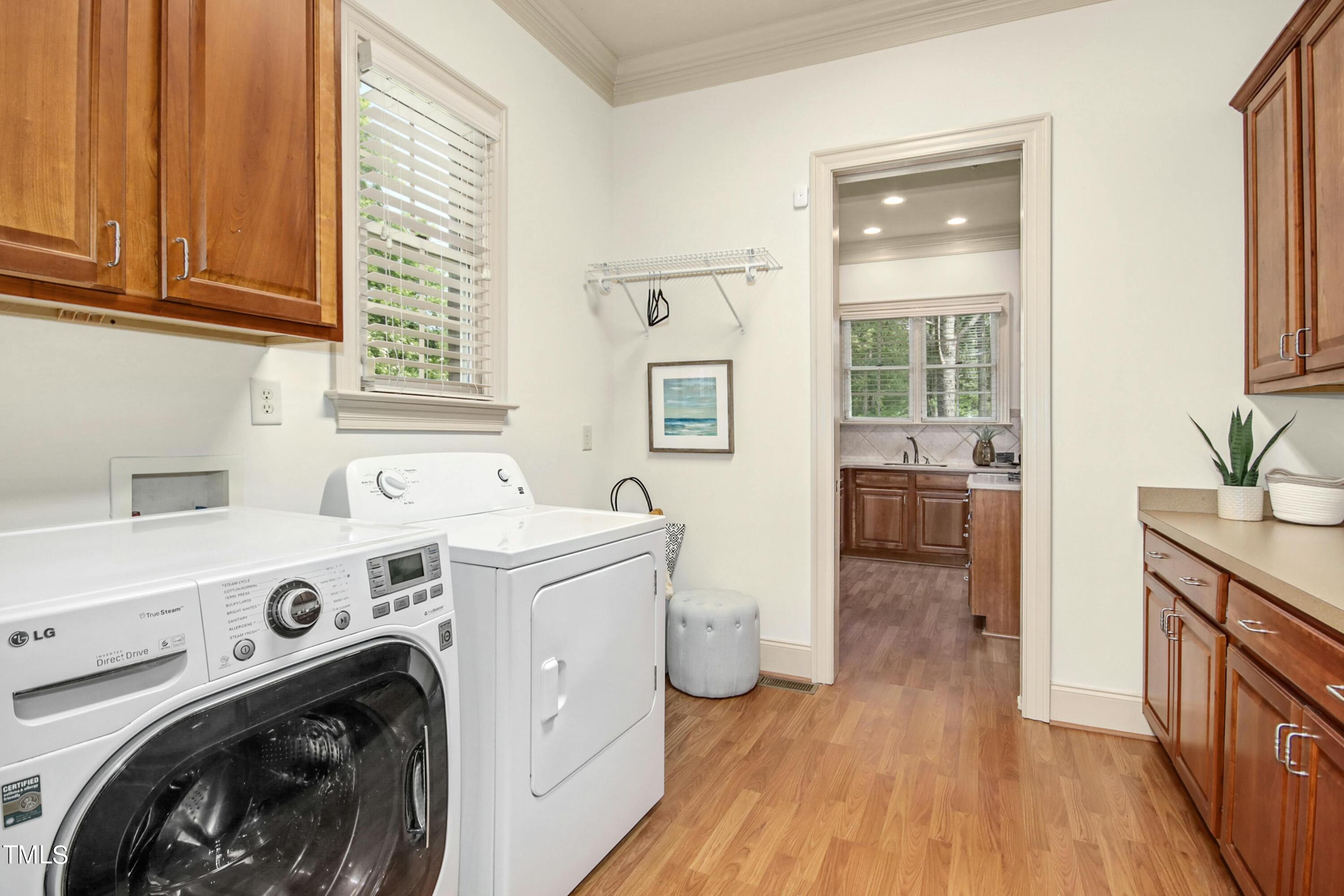 5513 Hickory Leaf Drive Raleigh, NC 27606 - Photo 38 of 41 a view of washer and dryer with kitchen in the background