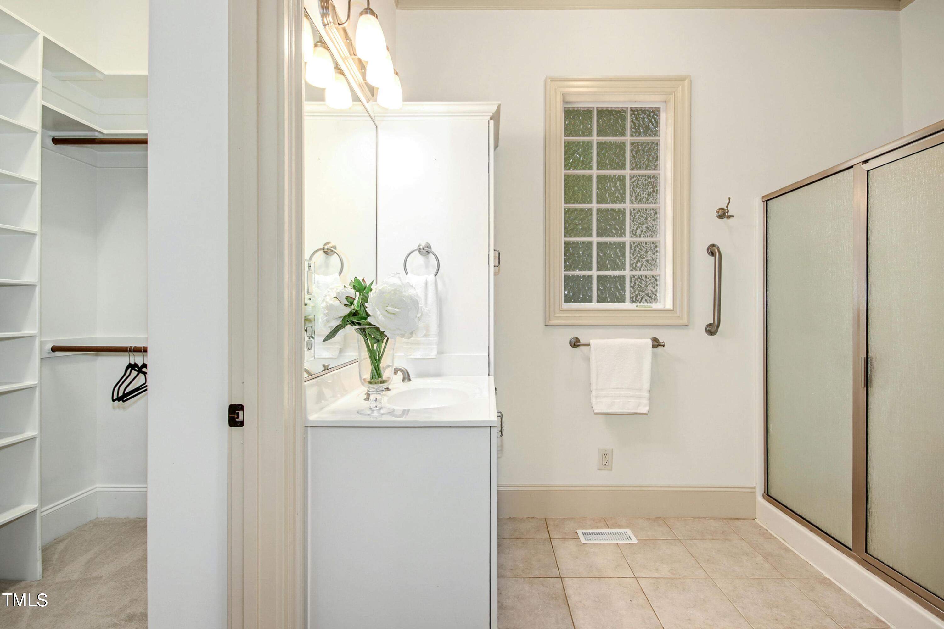 5513 Hickory Leaf Drive Raleigh, NC 27606 - Photo 39 of 41 a bathroom with a granite countertop shower a window and a sink