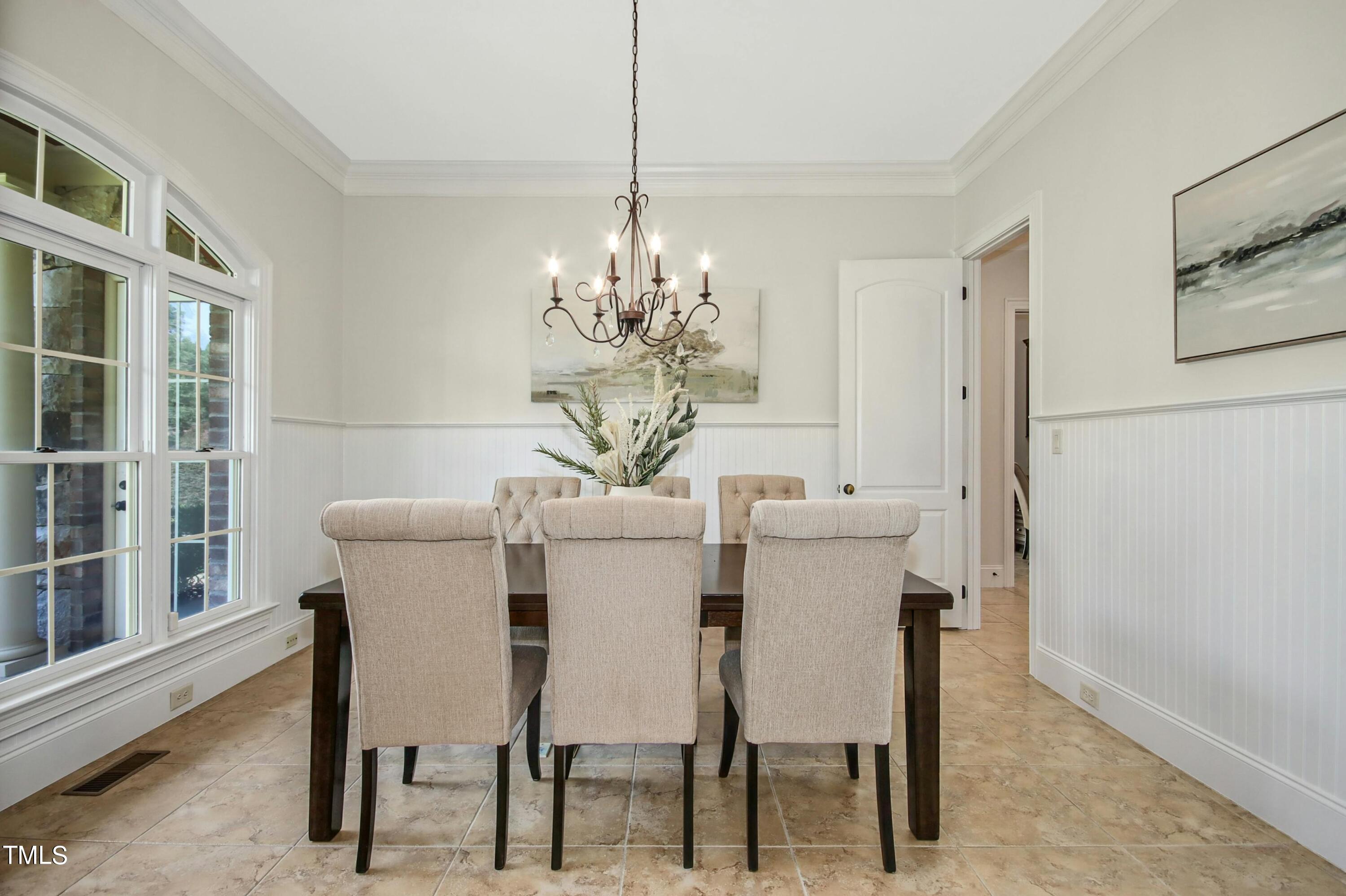 5513 Hickory Leaf Drive Raleigh, NC 27606 - Photo 5 of 41 a dining room with furniture a chandelier and wooden floor