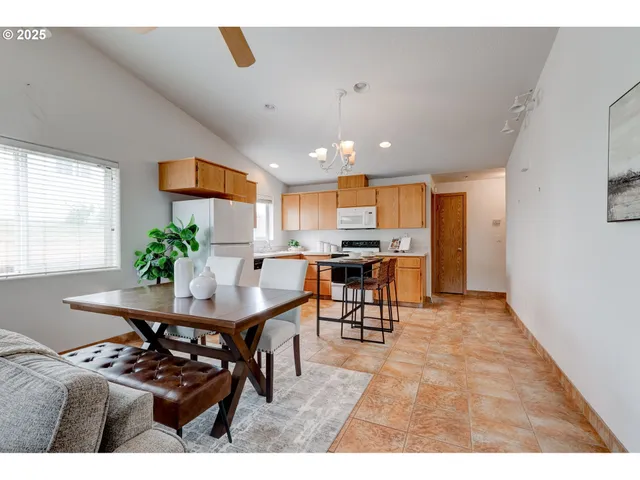 a living room with furniture and a dining table with kitchen view