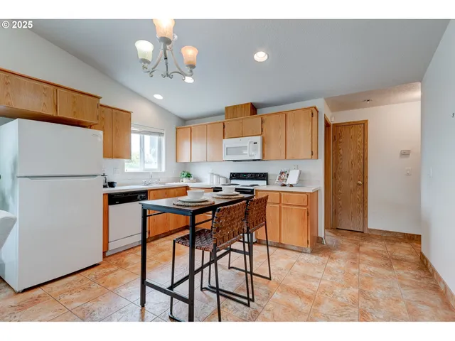 a kitchen with stainless steel appliances granite countertop a refrigerator a microwave oven a sink with island and chairs