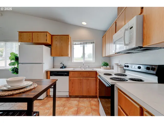 a kitchen with stainless steel appliances granite countertop a stove a sink dishwasher and a refrigerator with granite countertops