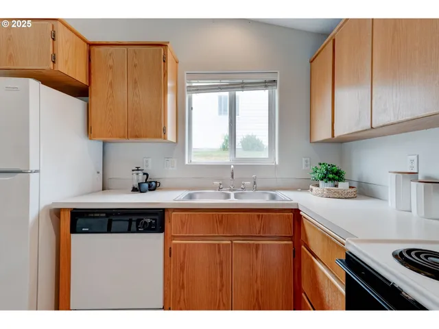 a kitchen with a sink a stove cabinets and a window