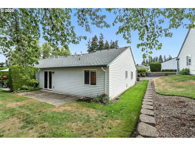 a view of backyard of house with wooden fence