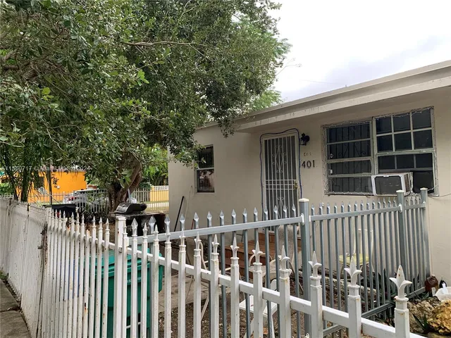 a view of a house with a small yard and wooden fence