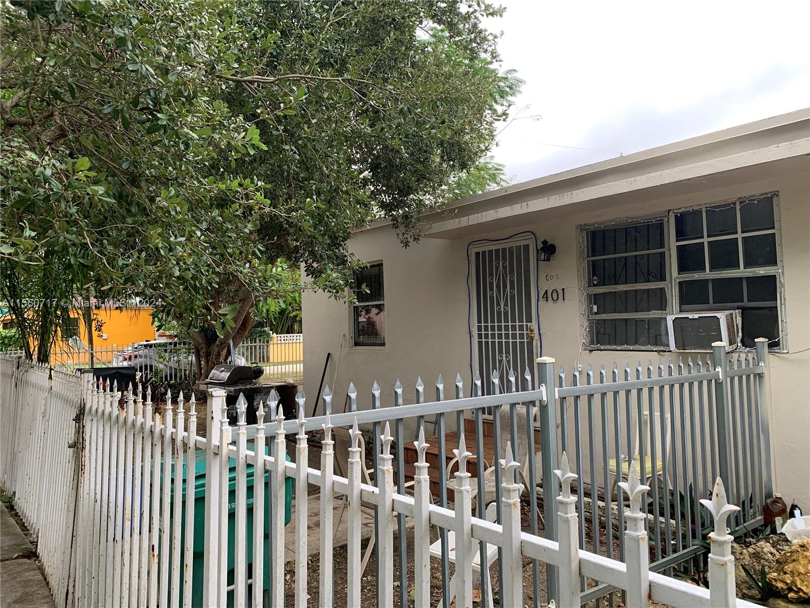 401 Northwest 81st Street Miami, FL 33150 - Photo 4 of 11 a view of a house with a small yard and wooden fence