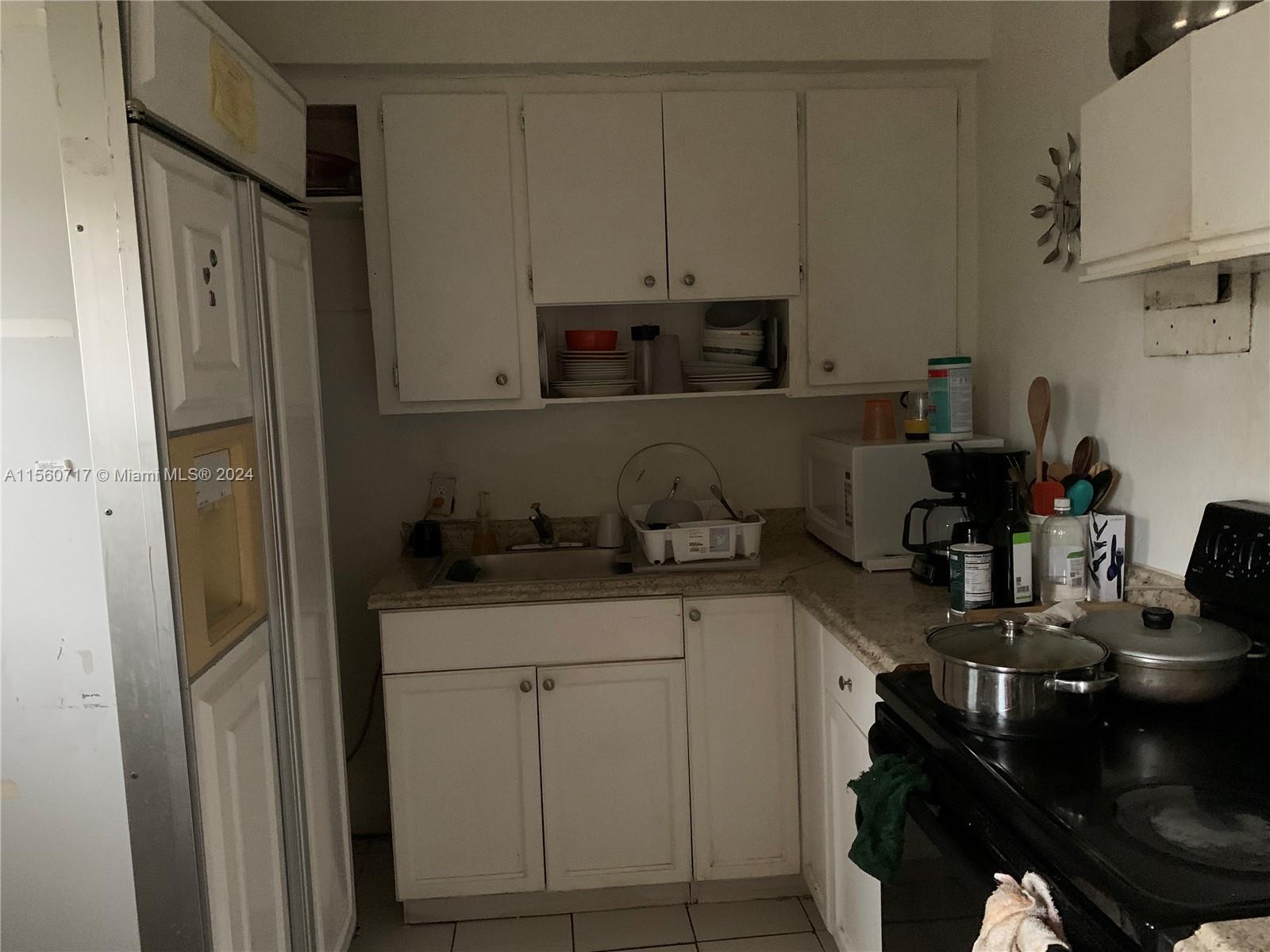 401 Northwest 81st Street Miami, FL 33150 - Photo 8 of 11 a kitchen with stainless steel appliances granite countertop a refrigerator and a stove top oven