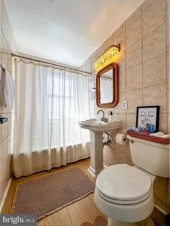 a bathroom with a toilet a sink and a mirror