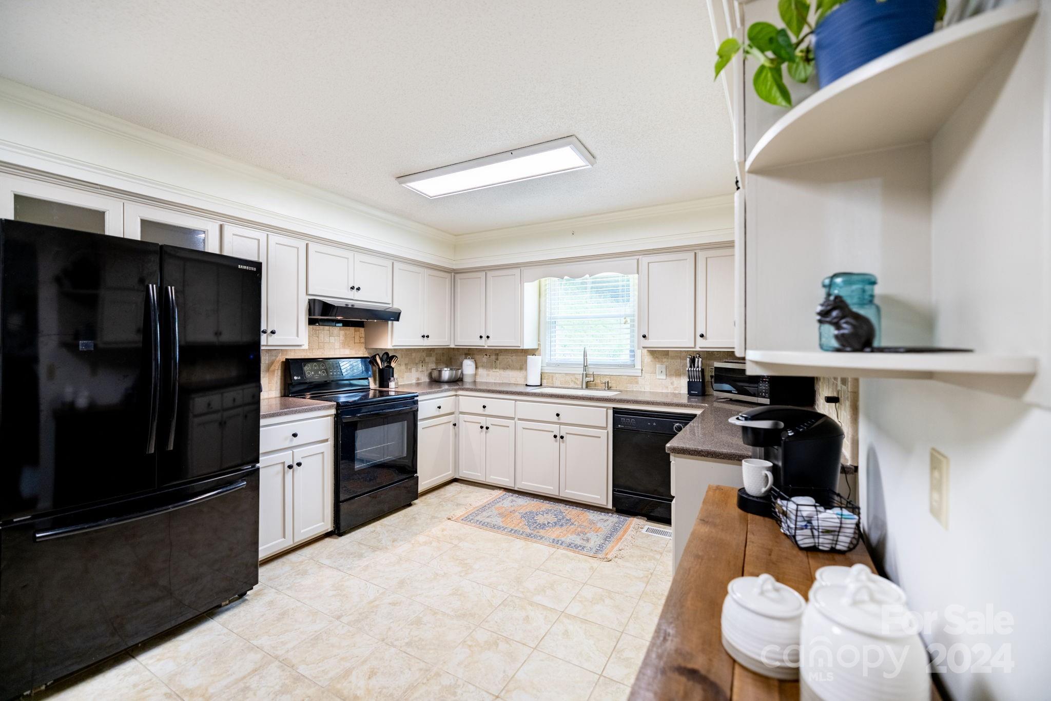779 Silas Creek Road, Unit 17 & 18 Lansing, NC 28643 - Photo 7 of 35 a kitchen with a refrigerator sink and white cabinets