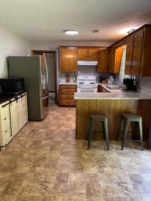 2050 Limekiln Road Tennessee Ridge, TN 37178 - Photo 13 of 37 a kitchen with stainless steel appliances a stove a refrigerator and chairs