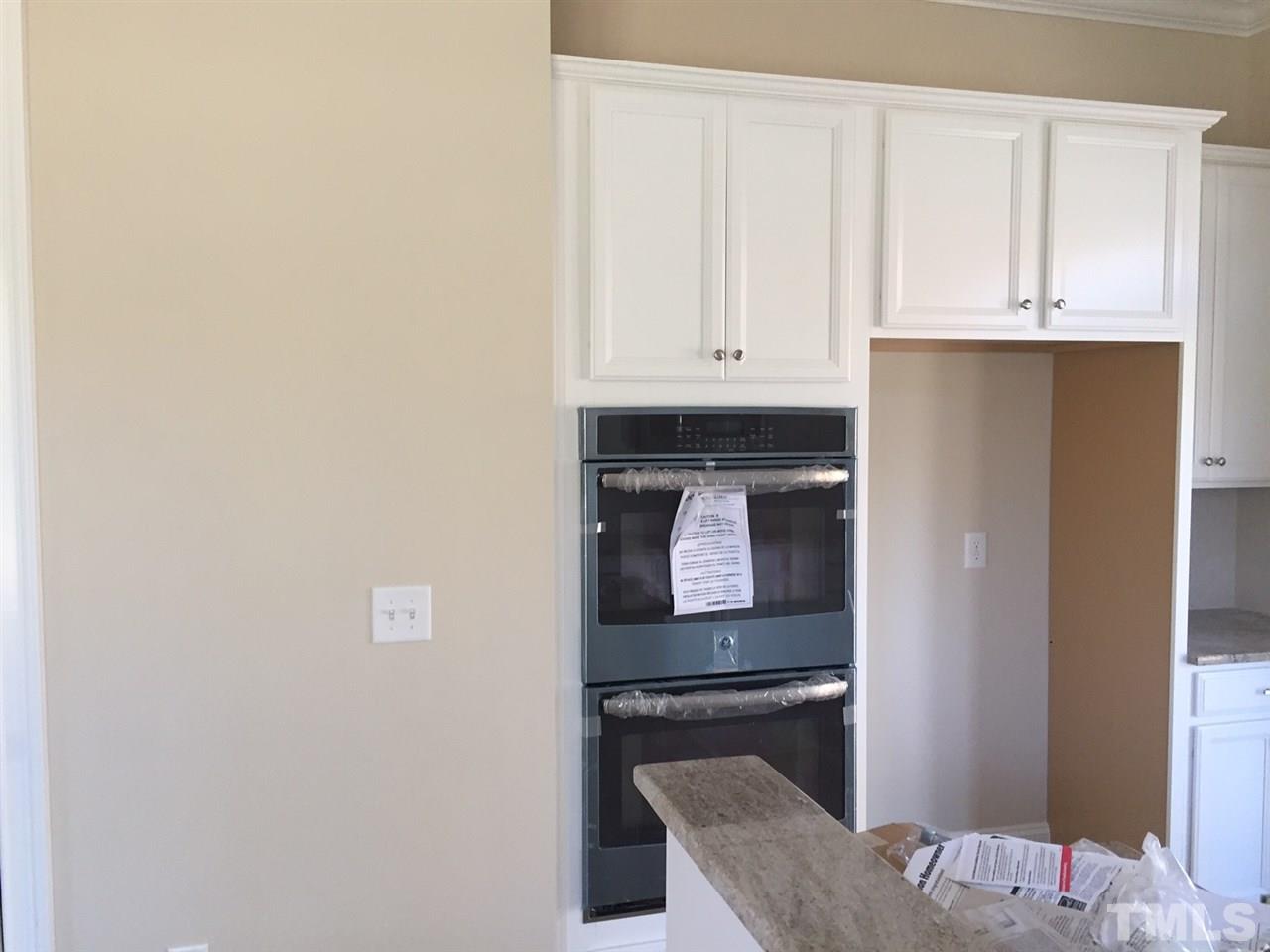 704 Fallon Grove Way Raleigh, NC 27608 - Photo 5 of 15 a kitchen with granite countertop white cabinets and stainless steel appliances