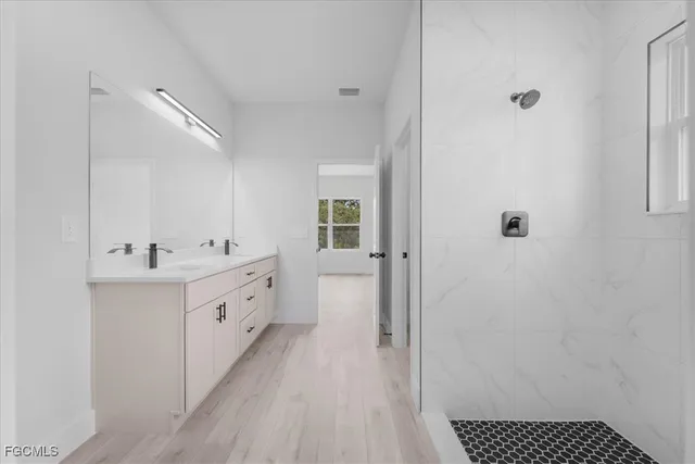 a bathroom with a double vanity sink a mirror and a shower