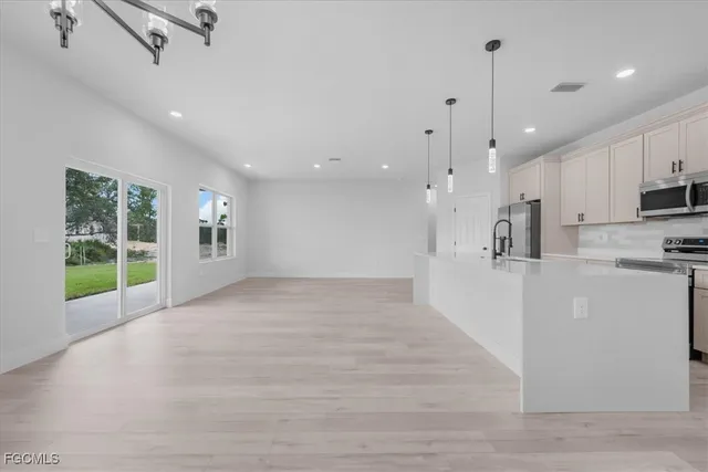 a view of large kitchen with a large window and stainless steel appliances