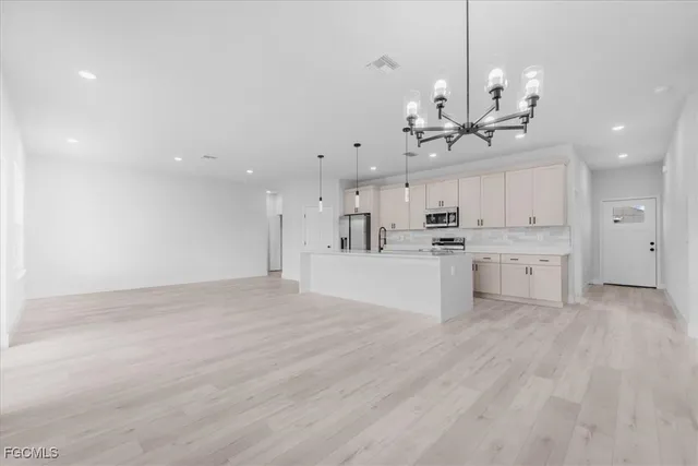 a view of a kitchen with kitchen island sink stainless steel appliances and cabinets