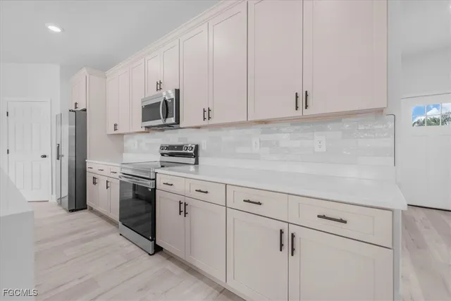 a kitchen with granite countertop white cabinets and stainless steel appliances