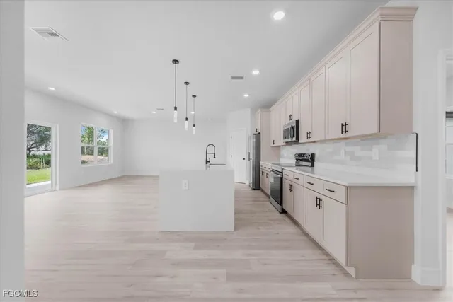 a large kitchen with cabinets and wooden floor
