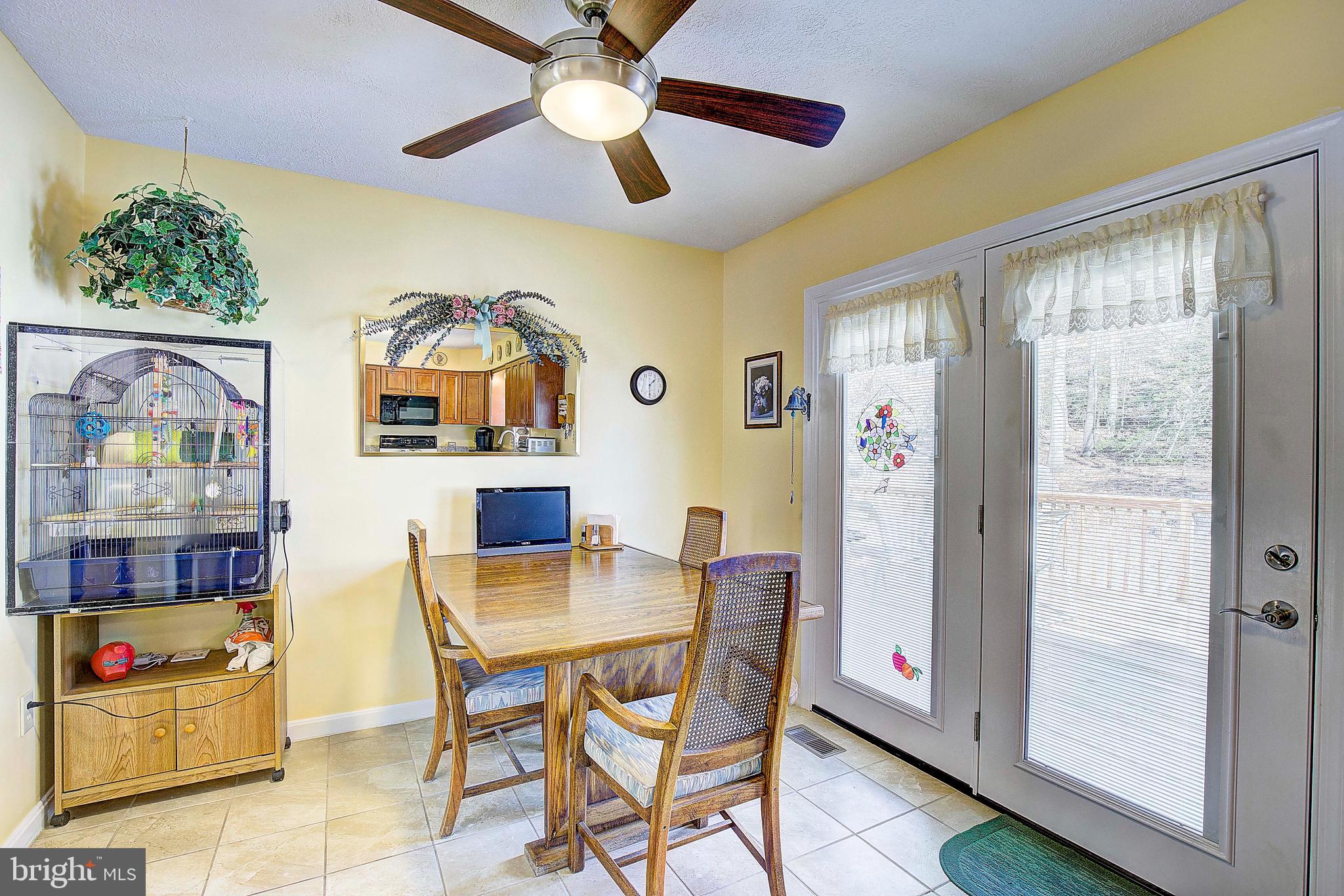 5018 Long Beach Road St. Leonard, MD 20685 - Photo 7 of 39 a view of a dining room with furniture and a chandelier fan