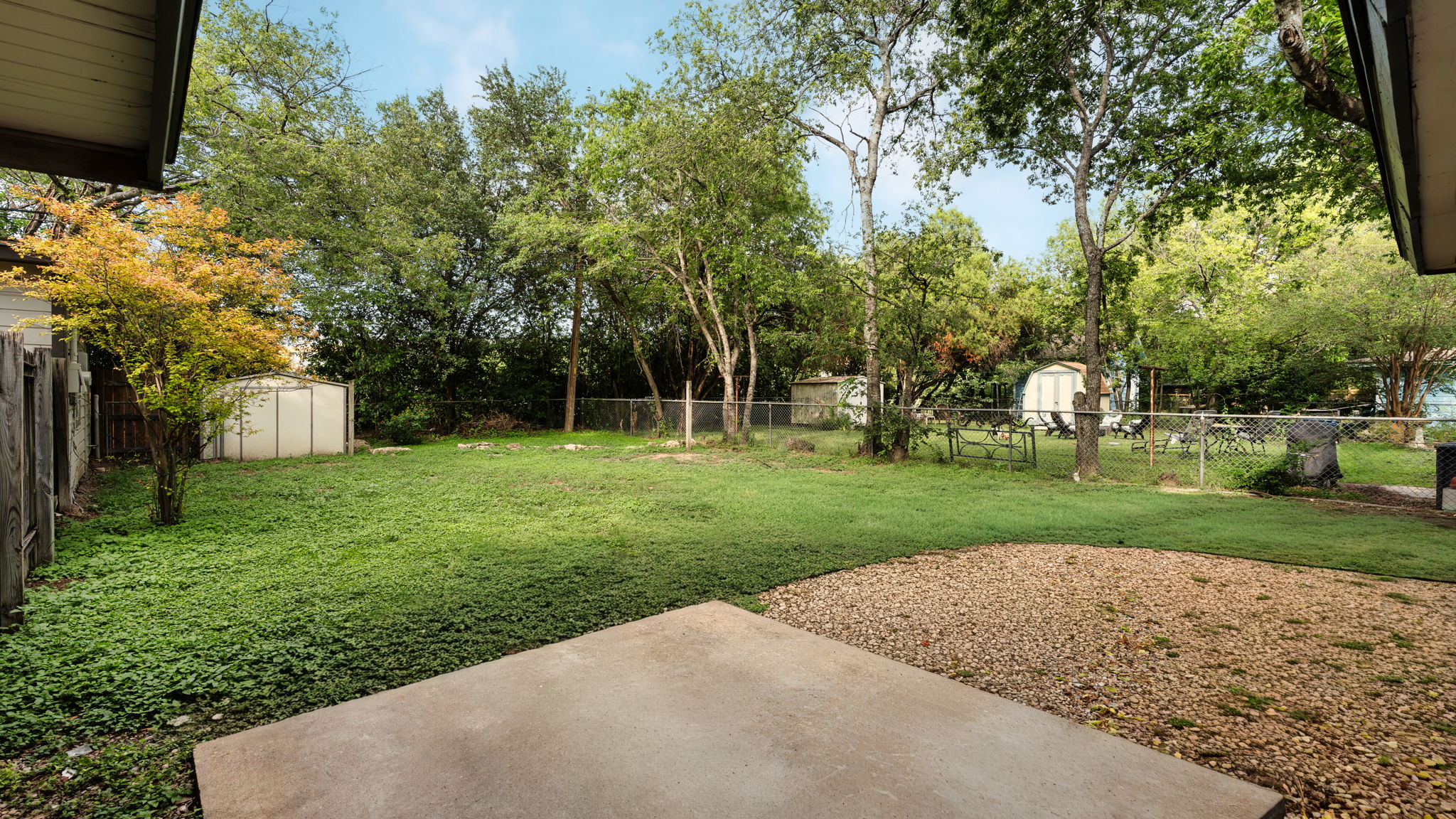 206 East Skyview Road Austin, TX 78752 - Photo 27 of 32 A spacious backyard with mature trees and a chain-link fence offers abundant room for outdoor enjoyment.