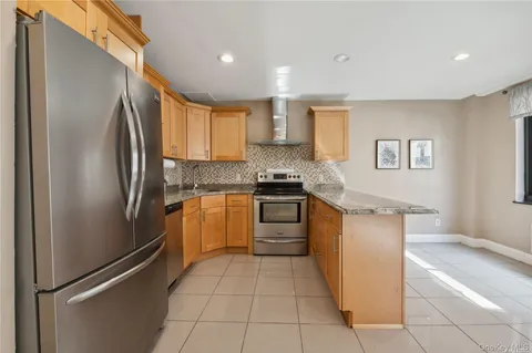 a kitchen with stainless steel appliances granite countertop a refrigerator and a stove top oven