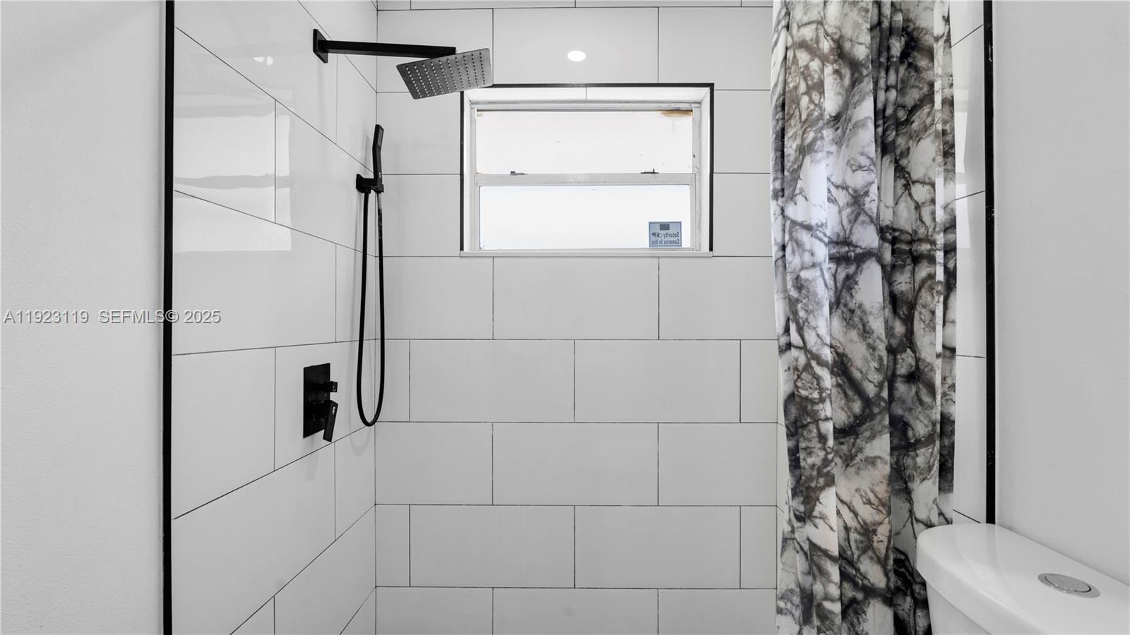 32 Southwest 9th Street, Unit 2 Hallandale Beach, FL 33009 - Photo 11 of 19 a bathroom with a shower curtain and a sink