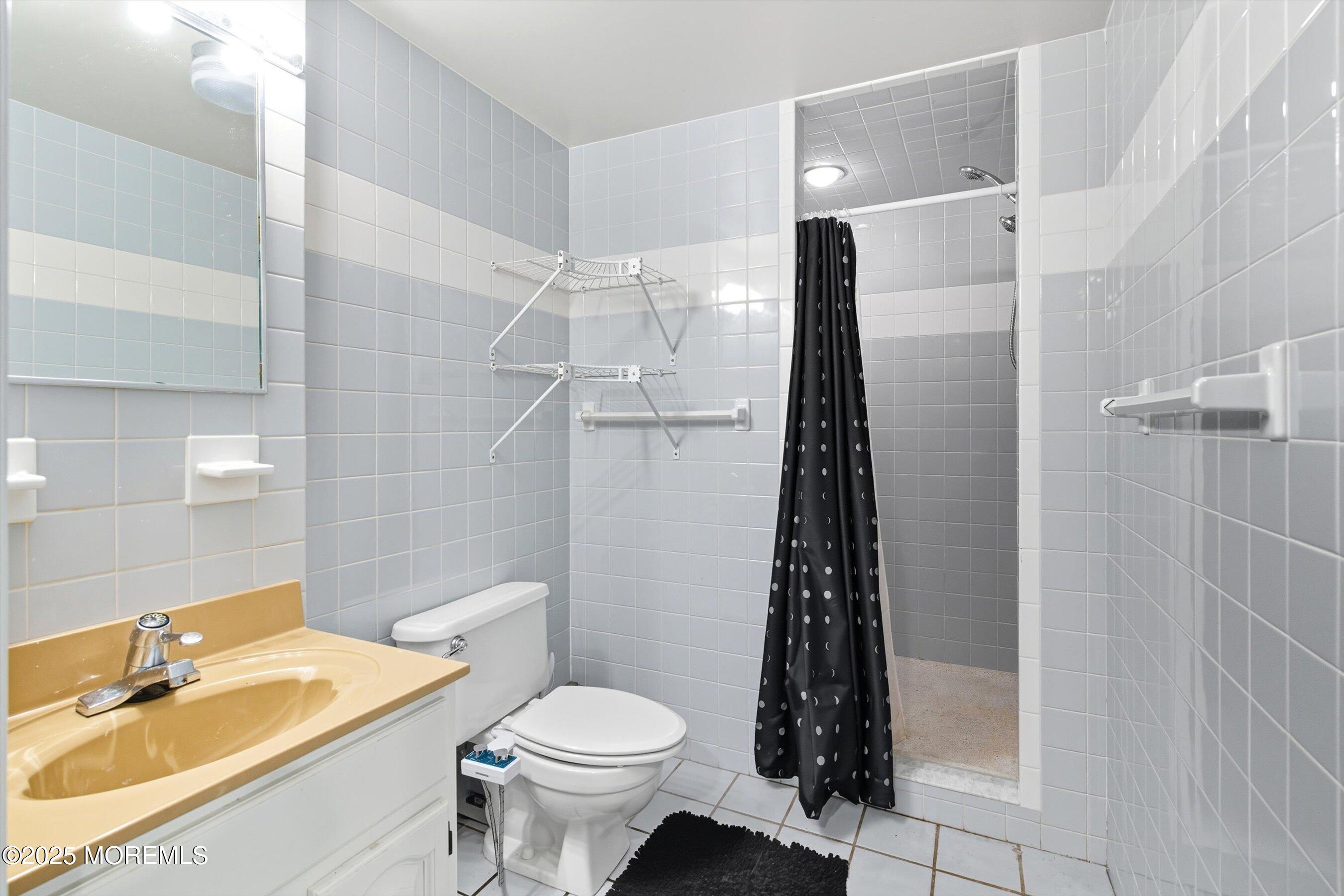 210 Coolidge Avenue Absecon, NJ 08201 - Photo 19 of 28 a bathroom with a sink a toilet a shower and a mirror