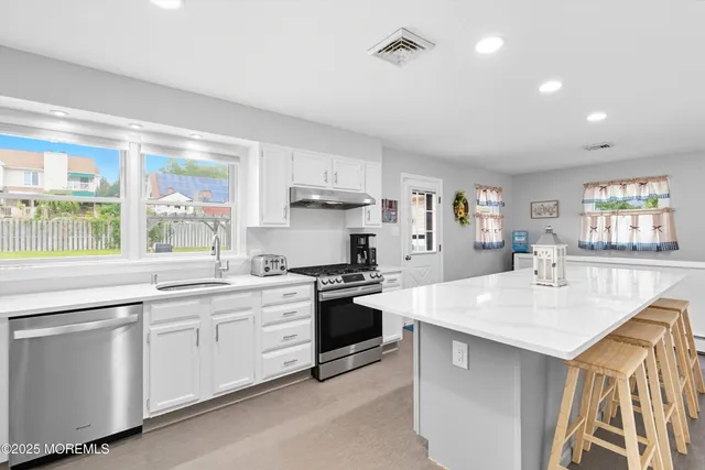 a kitchen with white cabinets and white appliances