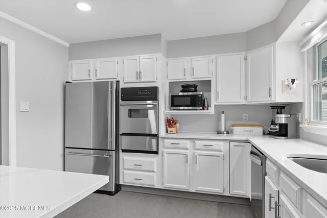 a kitchen with white cabinets and stainless steel appliances