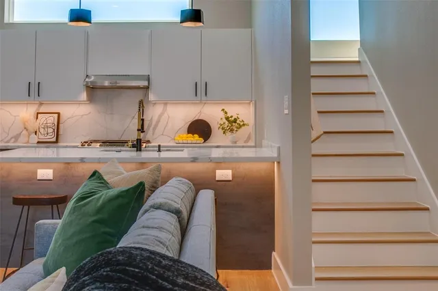 a kitchen with kitchen island a stove a chandelier and a view of living room
