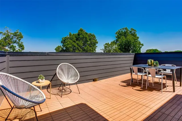 a backyard of a house with wooden floor table and chairs