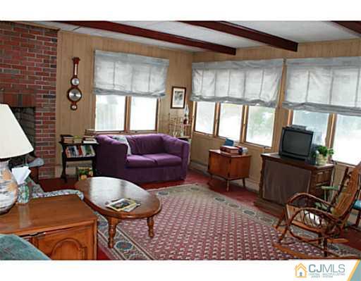 10 Bradford Road Edison, NJ 08820 - Photo 11 of 13 a living room with furniture a flat screen tv and a window