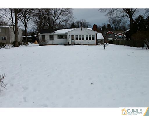10 Bradford Road Edison, NJ 08820 - Photo 12 of 13 a view of a large white house with a snow in the yard