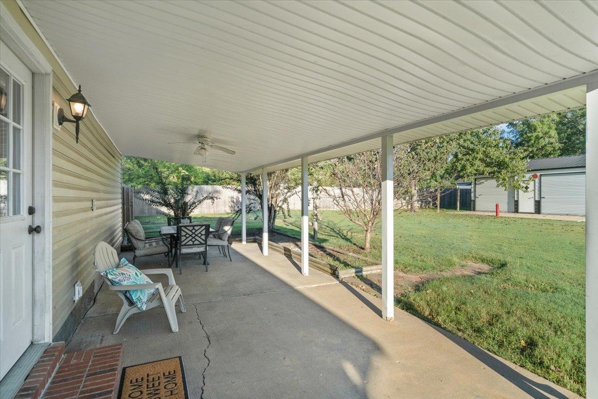 9496 Holly Grove Road Brighton, TN 38011 - Photo 22 of 29 Fenced backyard with outdoor dining area, a ceiling fan, and a patio