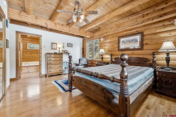 a bed sitting in a spacious bedroom next to a window
