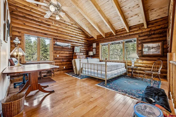 a bedroom with furniture wooden floor and a window