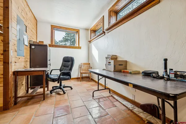 a view of a workspace with furniture and a window
