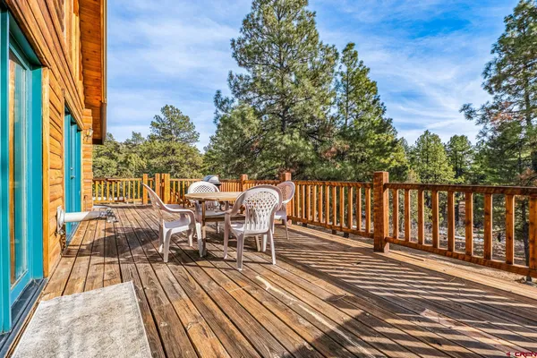 a view of a roof deck with table and chairs and wooden floor