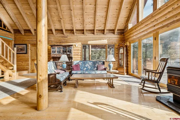 a living room with fireplace furniture and a large window