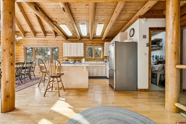 a kitchen with stainless steel appliances kitchen island granite countertop a refrigerator and a wooden cabinets