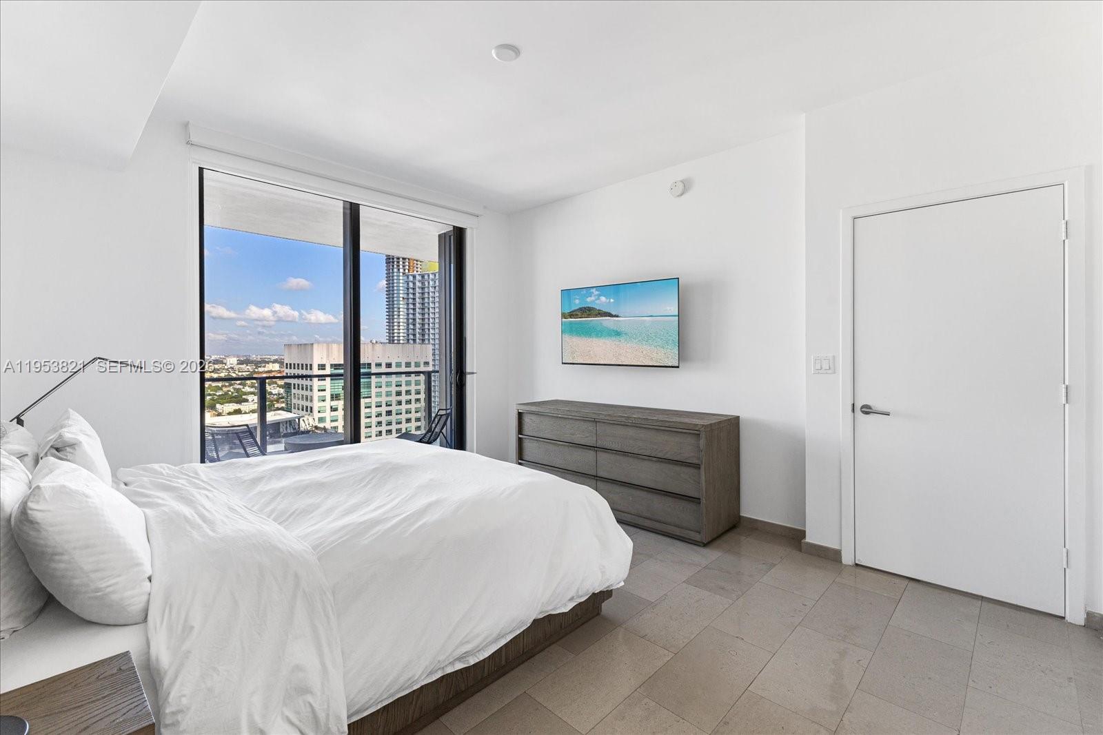 88 Southwest 7th Street, Unit 2506 Miami, FL 33130 - Photo 13 of 32 a bedroom with a bed and a large window