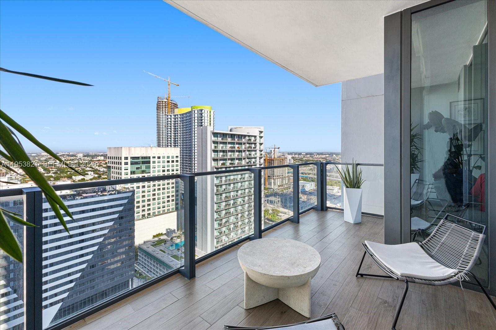 88 Southwest 7th Street, Unit 2506 Miami, FL 33130 - Photo 2 of 32 a view of a balcony with chairs and wooden floor