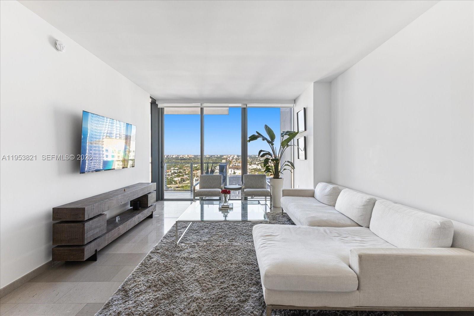 88 Southwest 7th Street, Unit 2506 Miami, FL 33130 - Photo 4 of 32 a living room with furniture and wooden floor