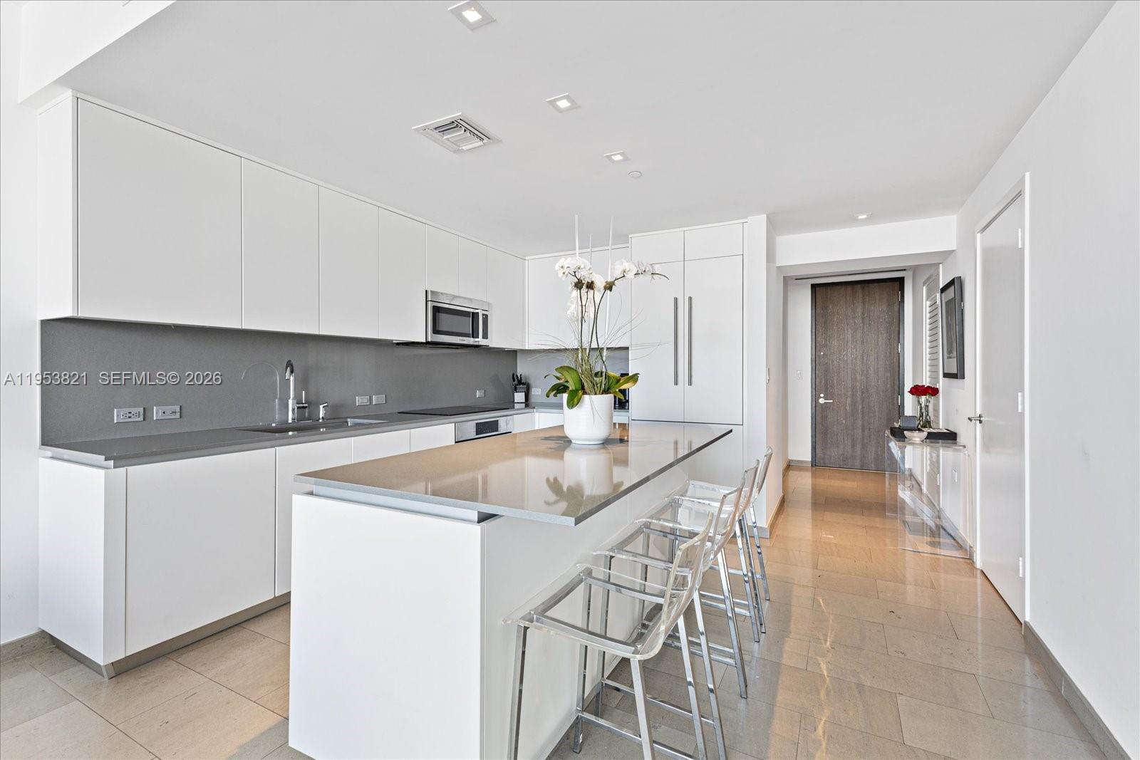 88 Southwest 7th Street, Unit 2506 Miami, FL 33130 - Photo 9 of 32 a kitchen with stainless steel appliances granite countertop a sink and a refrigerator
