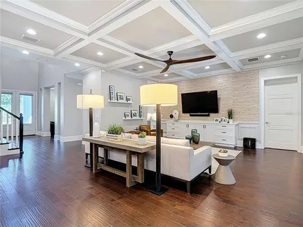 a living room with furniture kitchen view and a chandelier