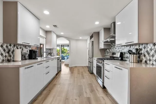 a large kitchen with stainless steel appliances lots of counter space and wooden floor