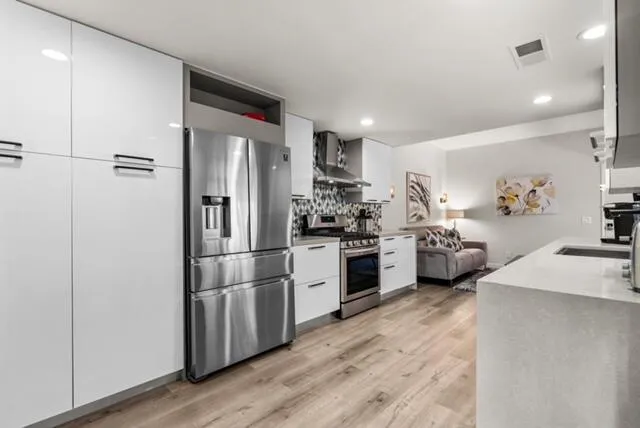 a kitchen with stainless steel appliances a refrigerator sink and stove